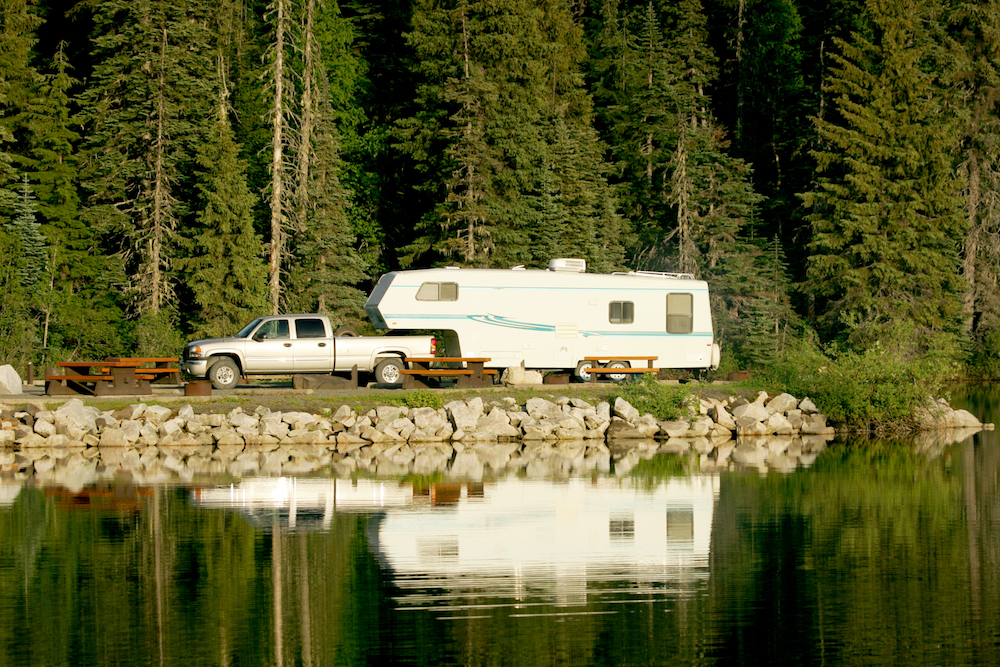 a fifth wheel camper beside a lake in Canada
